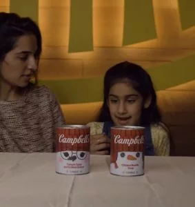 family-interacting-with-campbells-soup-candles-283x300