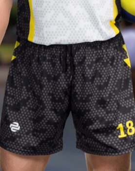 A person wearing black and gray camo-patterned sports shorts with the number 18 and a logo.