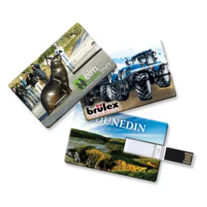 Three USB drives with scenic and branded designs: one with a group and a seal, another featuring a tractor with brülex branding, and the third displaying a landscape with UNEDIN text. Promote in style using these custom-shaped USB drives for an eye-catching USB drive promotion.