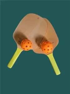 Promotional Pickleball Merch | Two wooden paddles with orange balls.
