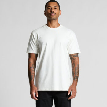 Man wearing an Ascolour T-shirt and black pants, standing against a plain background.