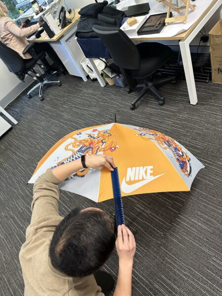 man measuring the height of a logo on an umbrella
