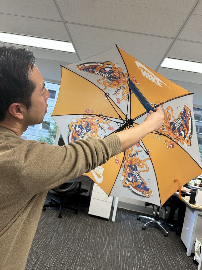 Man inspecting underside of a branded umbrella for quality
