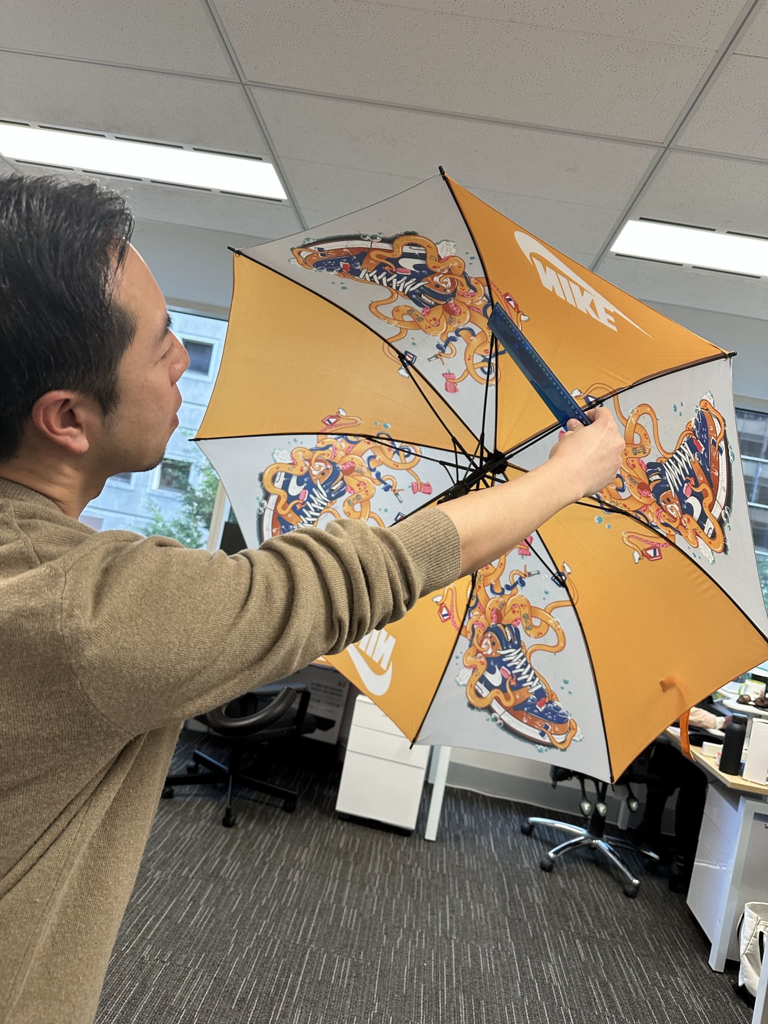 Man inspecting underside of a branded umbrella for quality