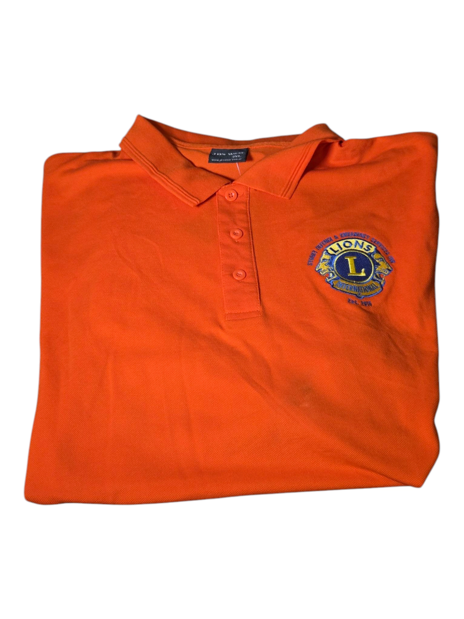 Folded orange polo shirt with Lions Club emblem