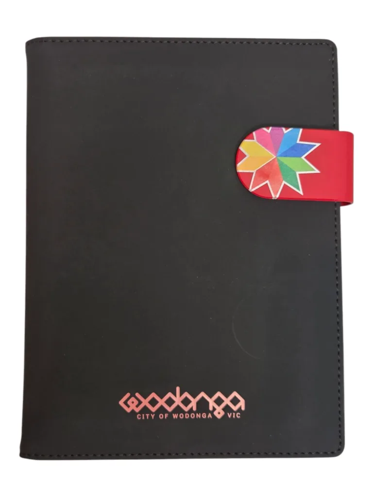 Black notebook with a colorful geometric design and City of Wodonga VIC on the cover.