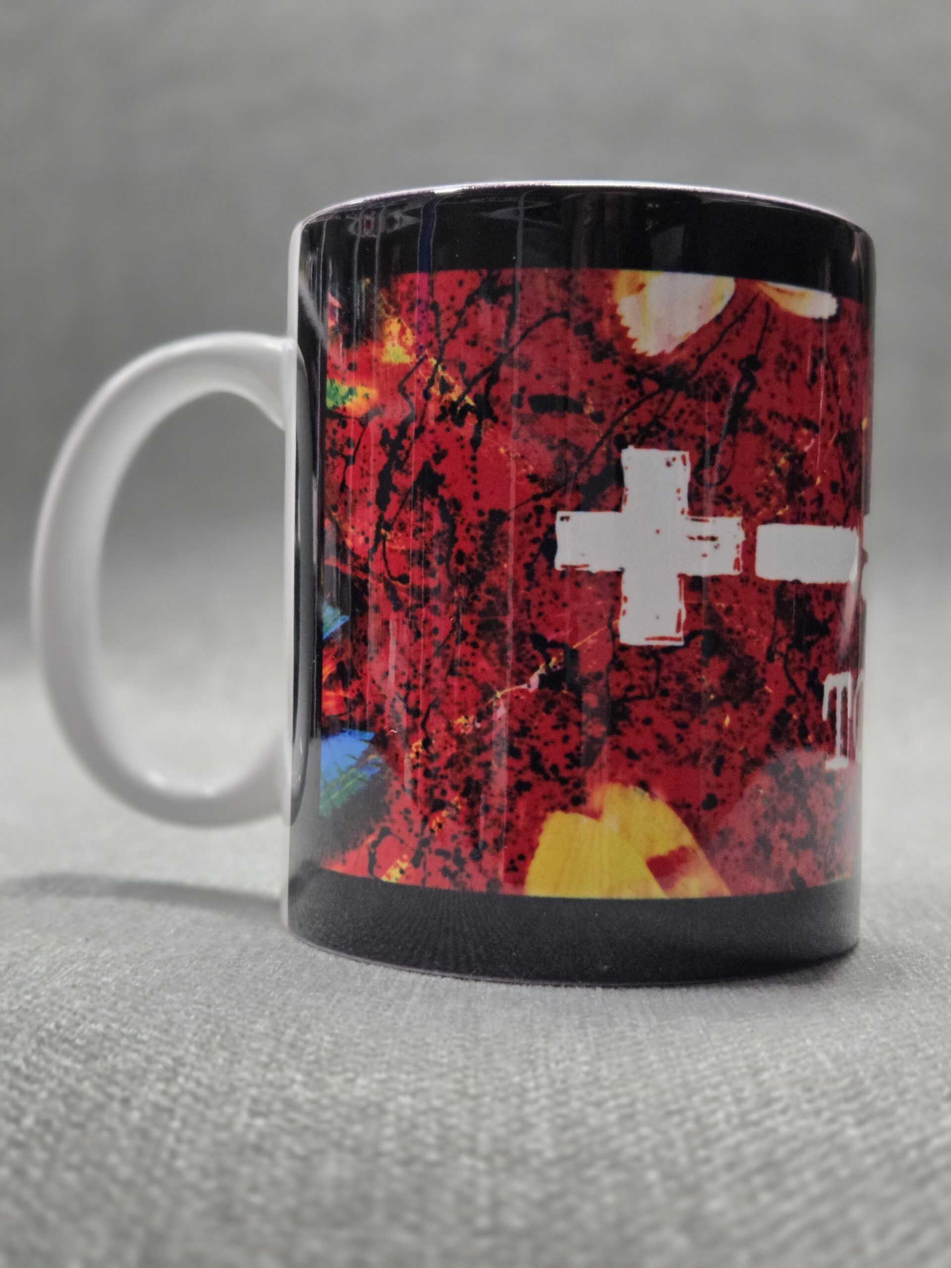 A white mug with colorful abstract red and yellow designs, perfect for merch marketing.