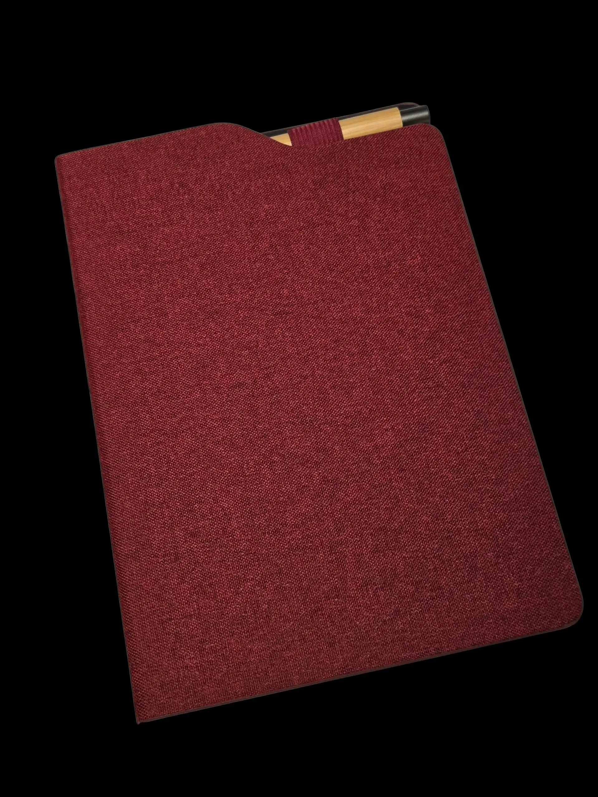 Red luxury merchandise folder with a pen tucked inside, set against a black background.