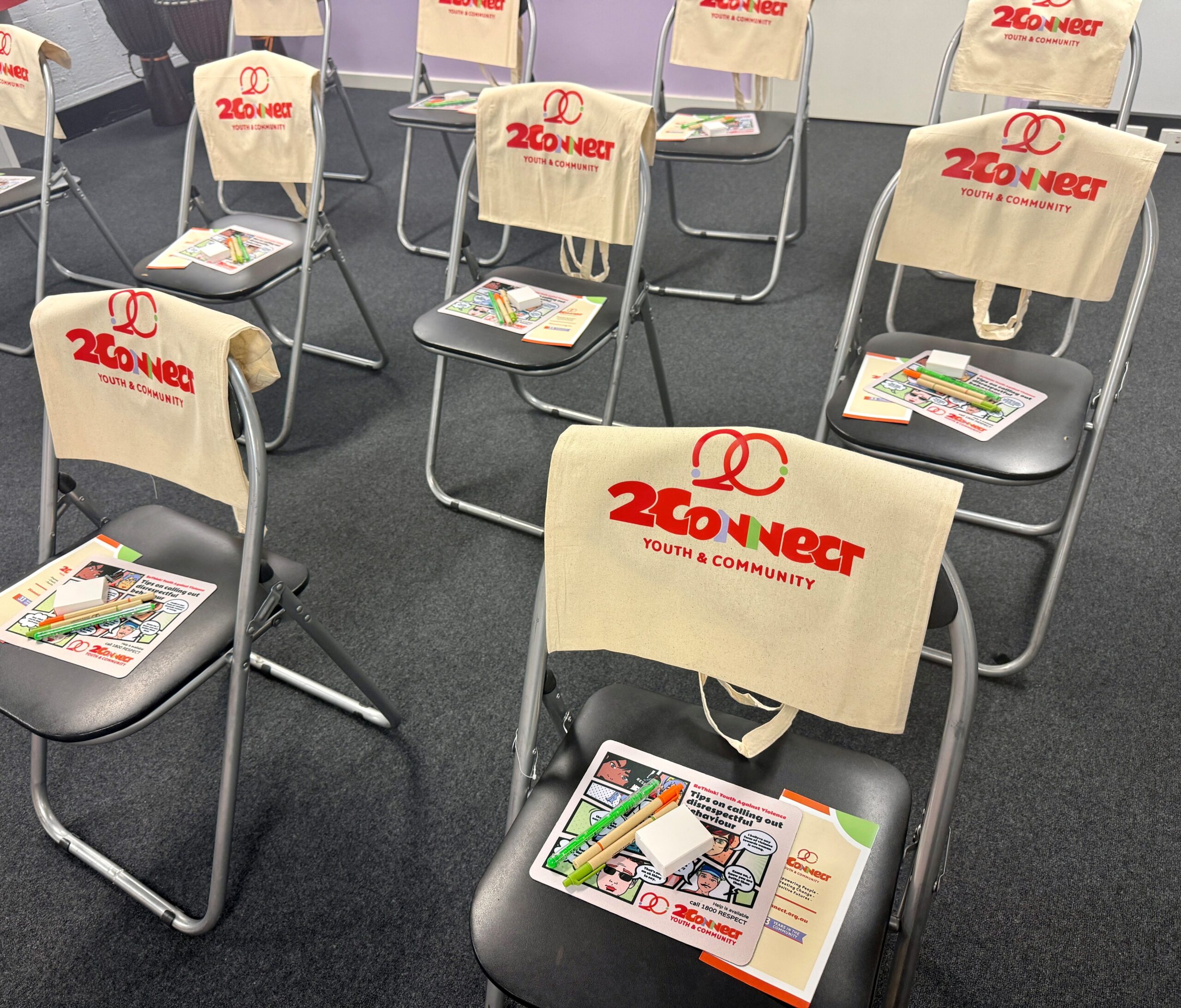 Rows of chairs with 2Connect Youth custom merchandise and pamphlets on each seat, fostering community.