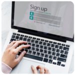 Hands typing on a laptop with a sign-up form to help achieve business goals.