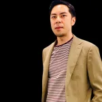 Man wearing a tan blazer over a striped shirt