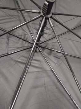 Inside view of open black umbrellas, showing metal spokes and central shaft.
