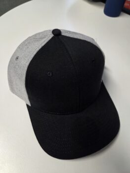 A stylish black and gray cap displayed on a white surface.