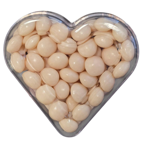 Heart-shaped container filled with round, pale beige jelly beans or beads.