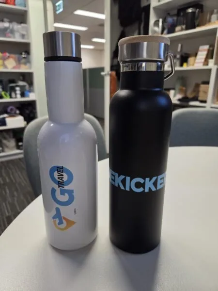 Two reusable water bottles on a table, captured as user generated content in an office setting.