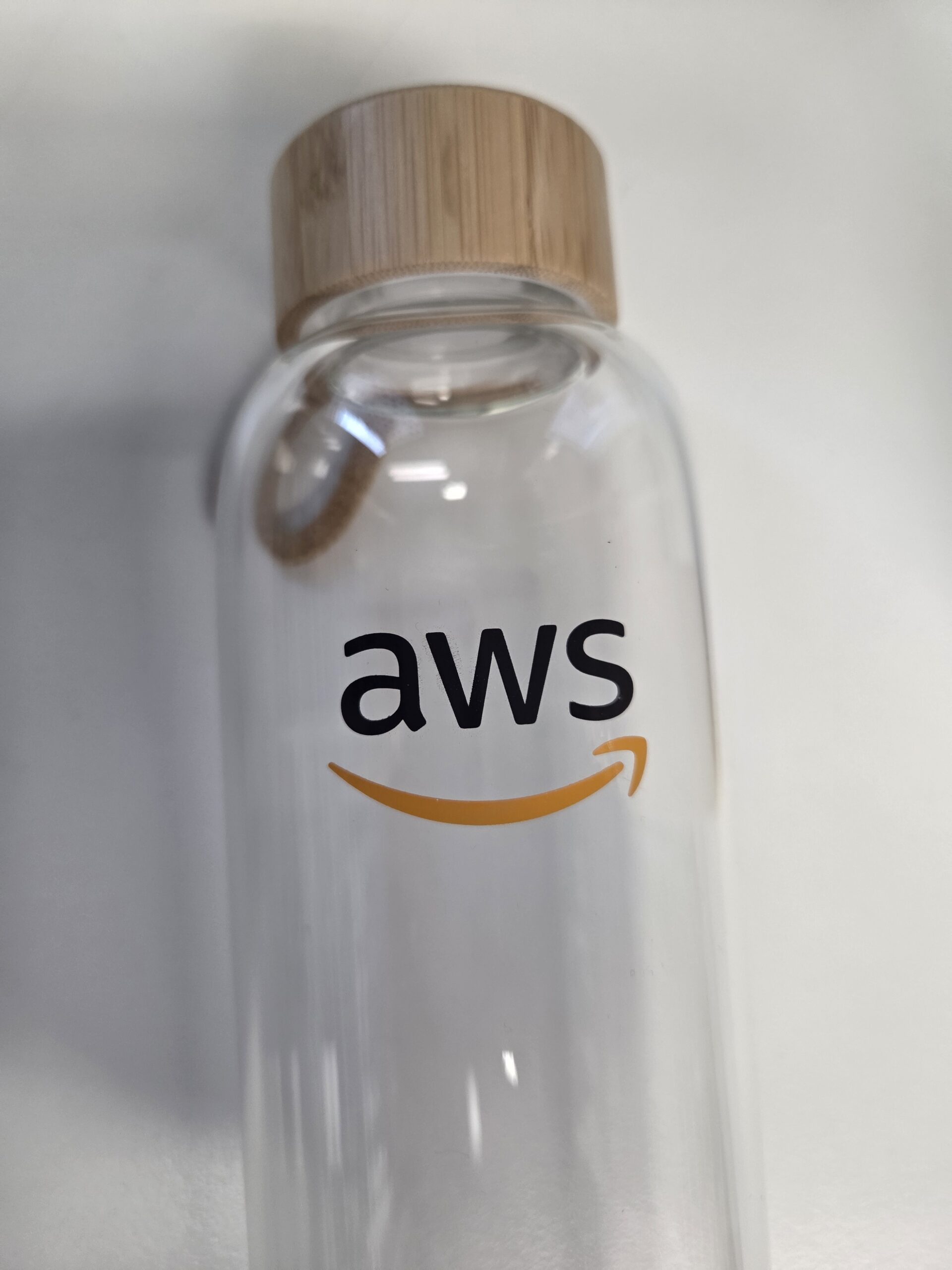 Clear glass bottle with wooden cap, featuring the AWS logo—wondering which bottle this is?.