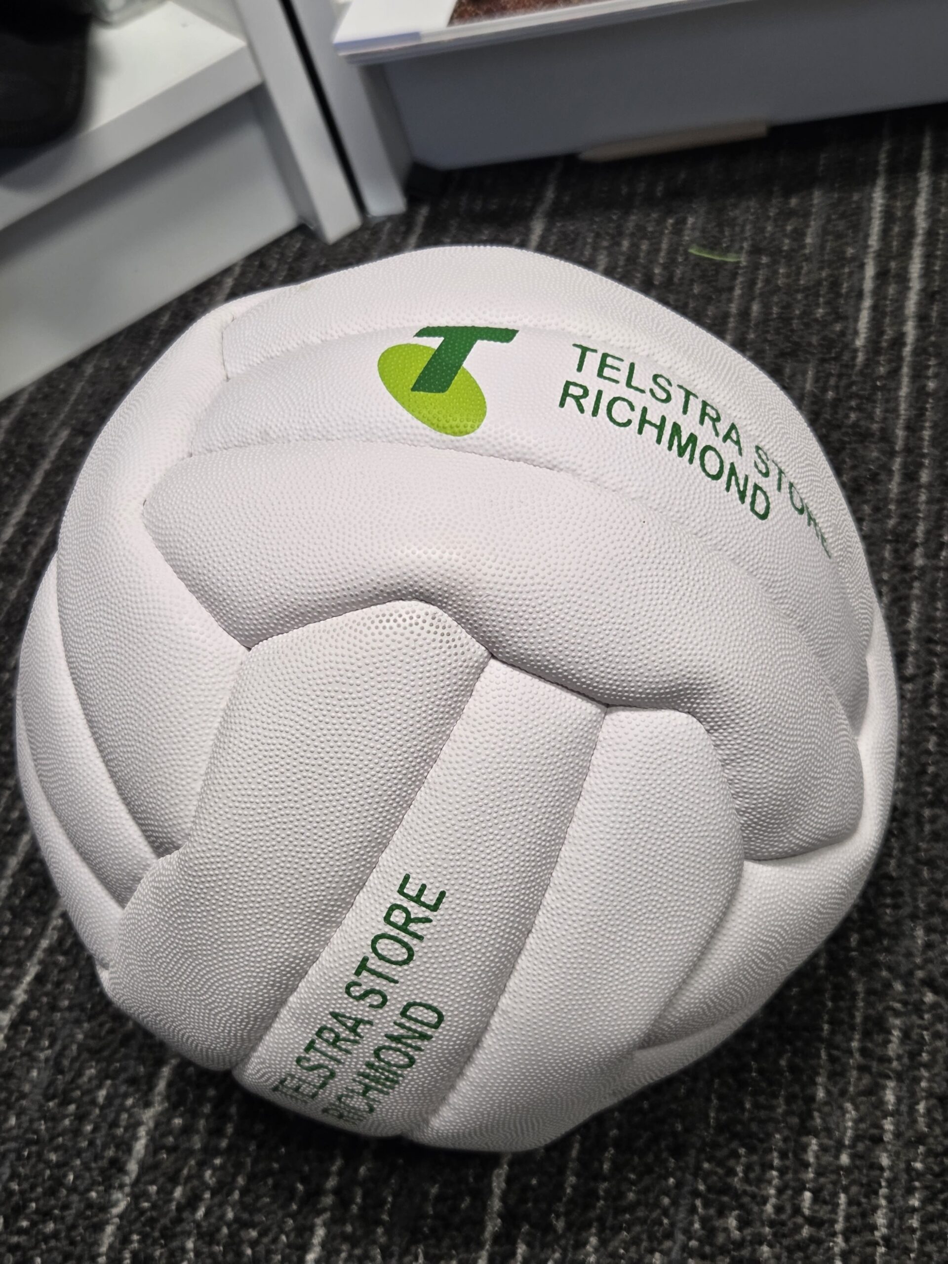 another angle of the while volleyball with Telstra Store Richmond logo
