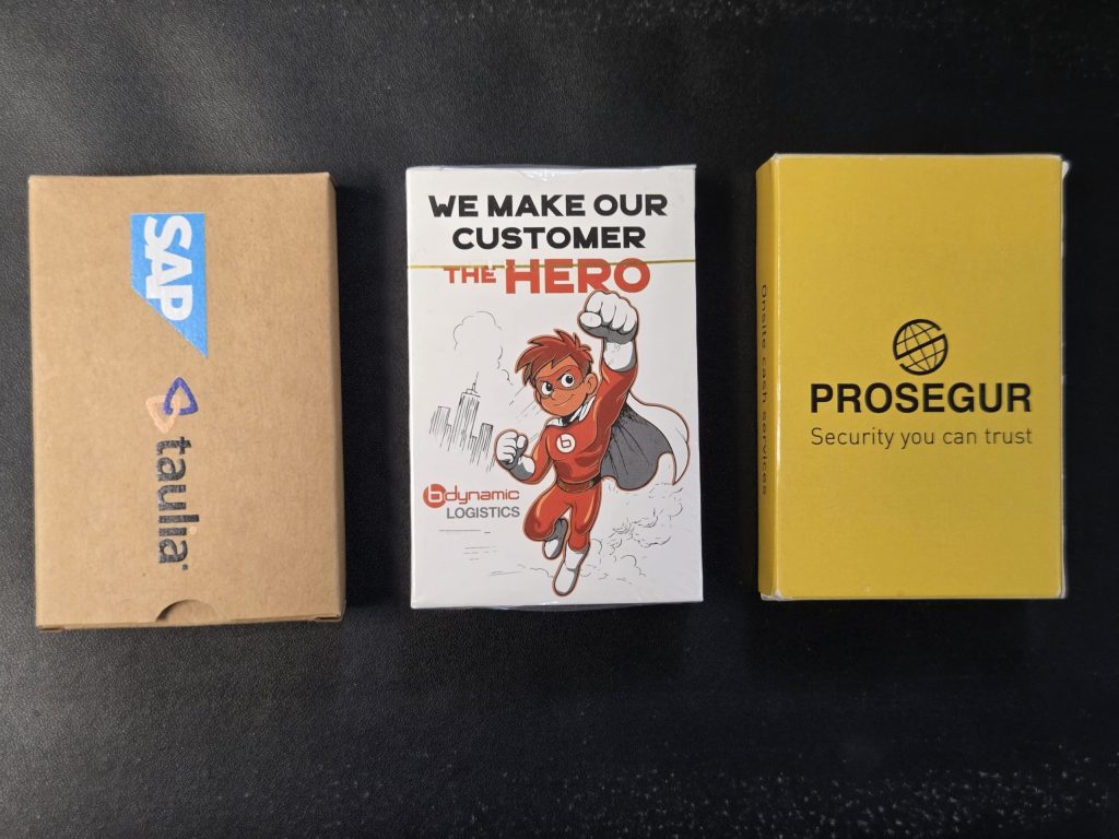 Three branded card boxes for promotional games: SAP Taulia, Dynamic Logistics Hero, Prosegur.