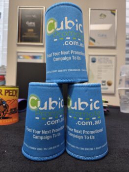 blue stubby coolers with Cubic Promote logo on a pile