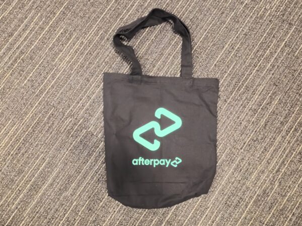 Calico Cotton Bag featuring the Afterpay logo on a gray striped carpet.