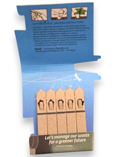 Blue seed packet with basil seeds, eco-friendly messaging, and promotional seedsticks inside.