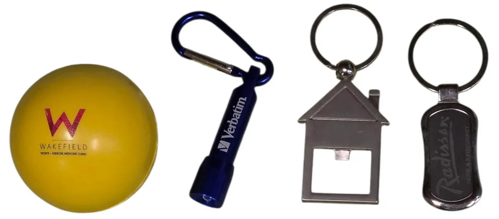 A yellow stress ball and three metal keyrings, including a house-shaped bottle opener.