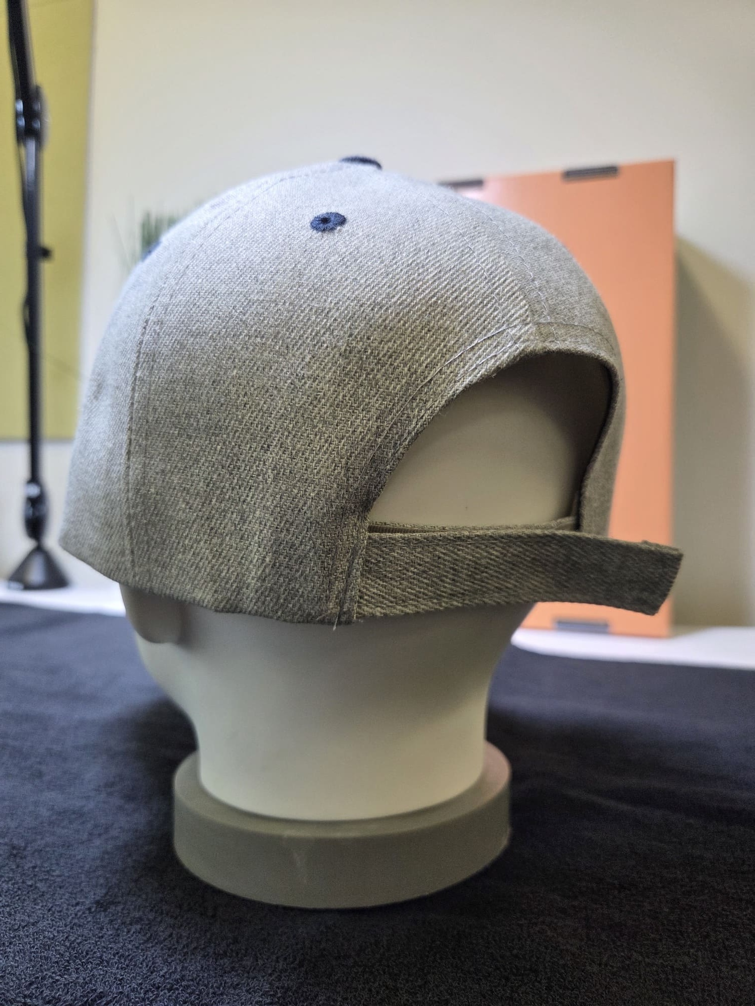 A gray Lumi baseball cap on a mannequin head, shown from the back.