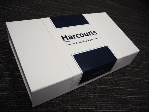 A white Harcourts gift box with navy accents, perfect for corporate gift box ideas.