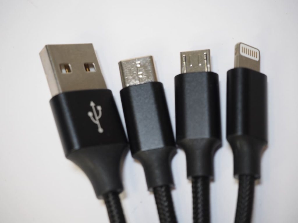 Four black custom charging cables: USB-A, USB-C, Micro-USB, and Lightning connectors.