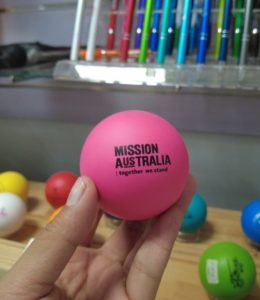 A hand holds one of the funnest promotional items—a pink ball labeled MISSION AUSTRALIA.