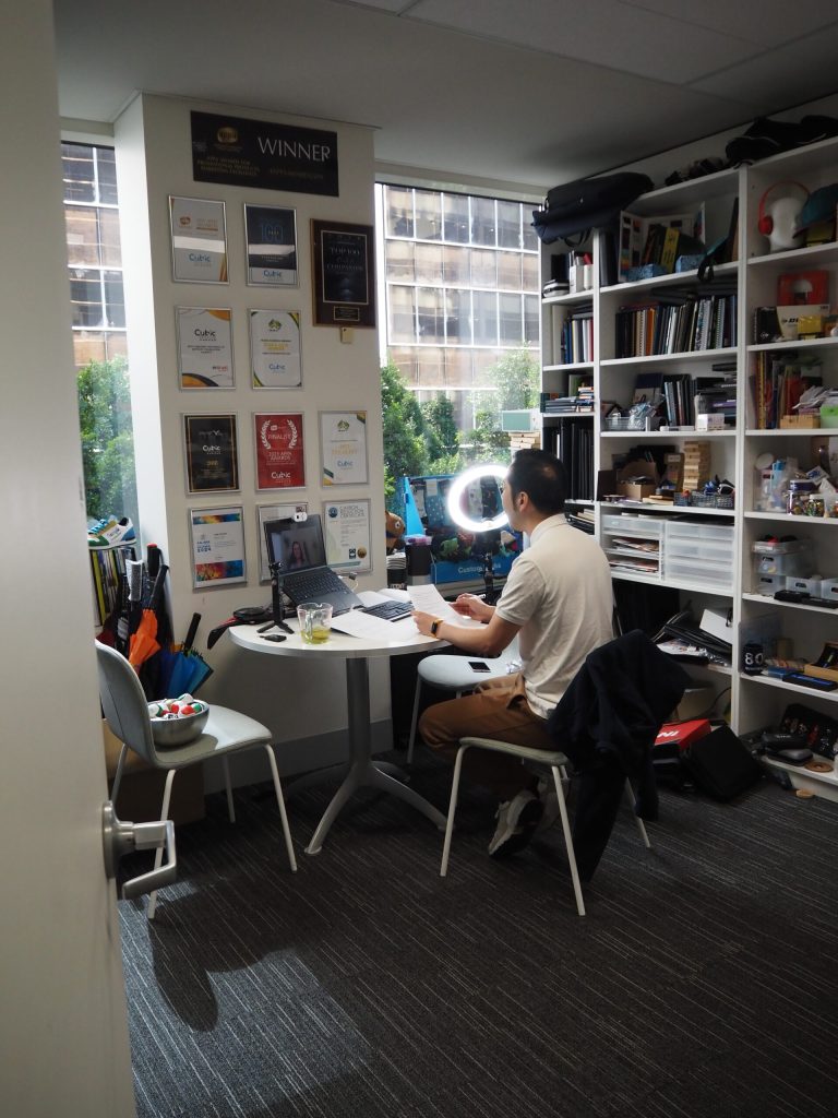Man working at a desk in a small office with APPA award plaques and shelves of books.