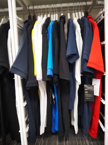 Assorted short-sleeve shirts perfect for a rebrand, in vibrant colors on white closet hangers.