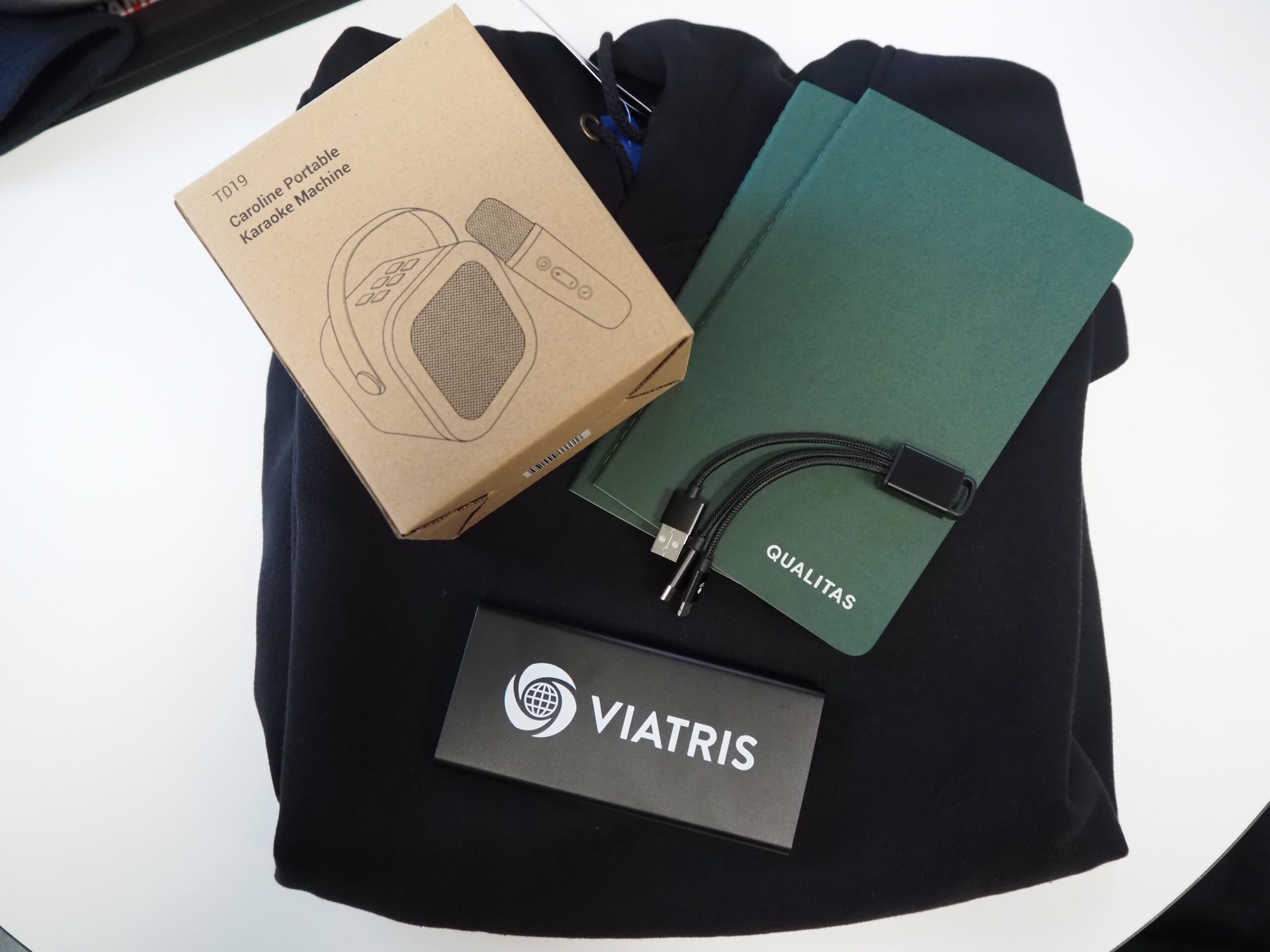 A branded welcome kit for new employees: hoodie, notebook, speaker, cable, and VIATRIS box.