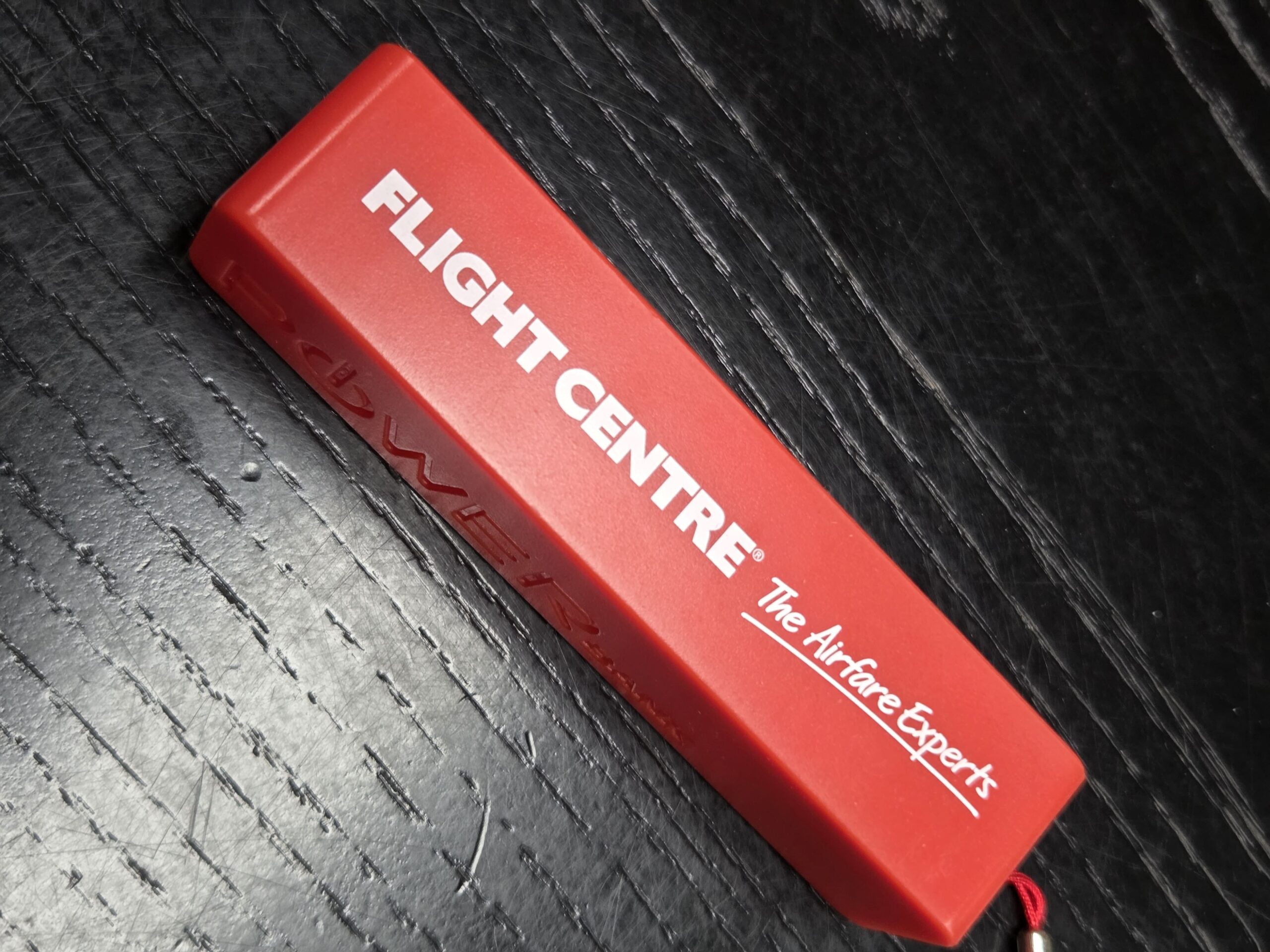 A red rectangular keychain featuring Flight Centre, the Airfare Experts, in bold white text.