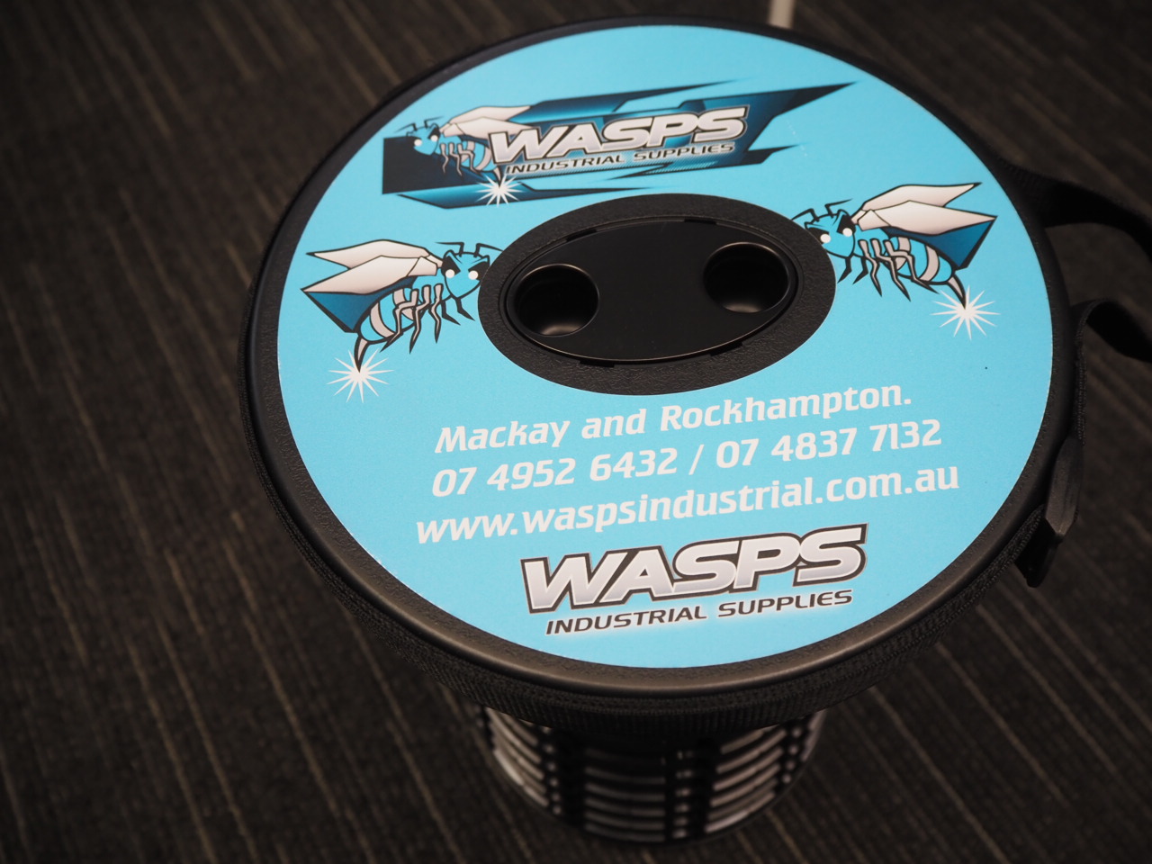 A spool labeled WASPS Industrial Supplies with contact details on a blue background.