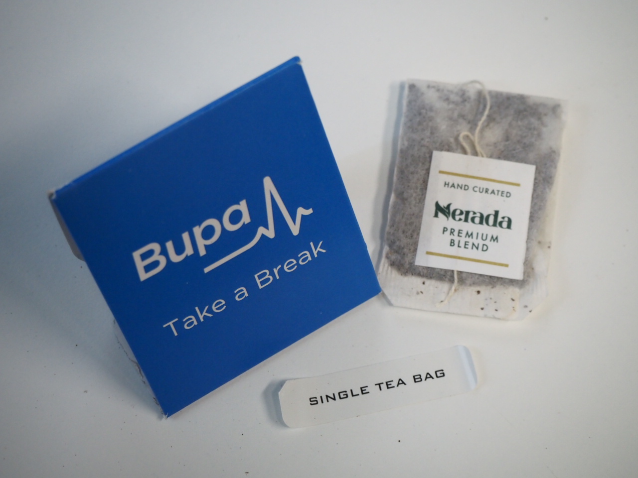 Blue Bupa box, Nerada Tea Bags, and a SINGLE TEA BAG label on a white surface.