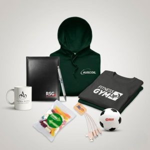 Assorted branded starter kit merchandise including clothing, mug, notepad, pen, candy, and more.