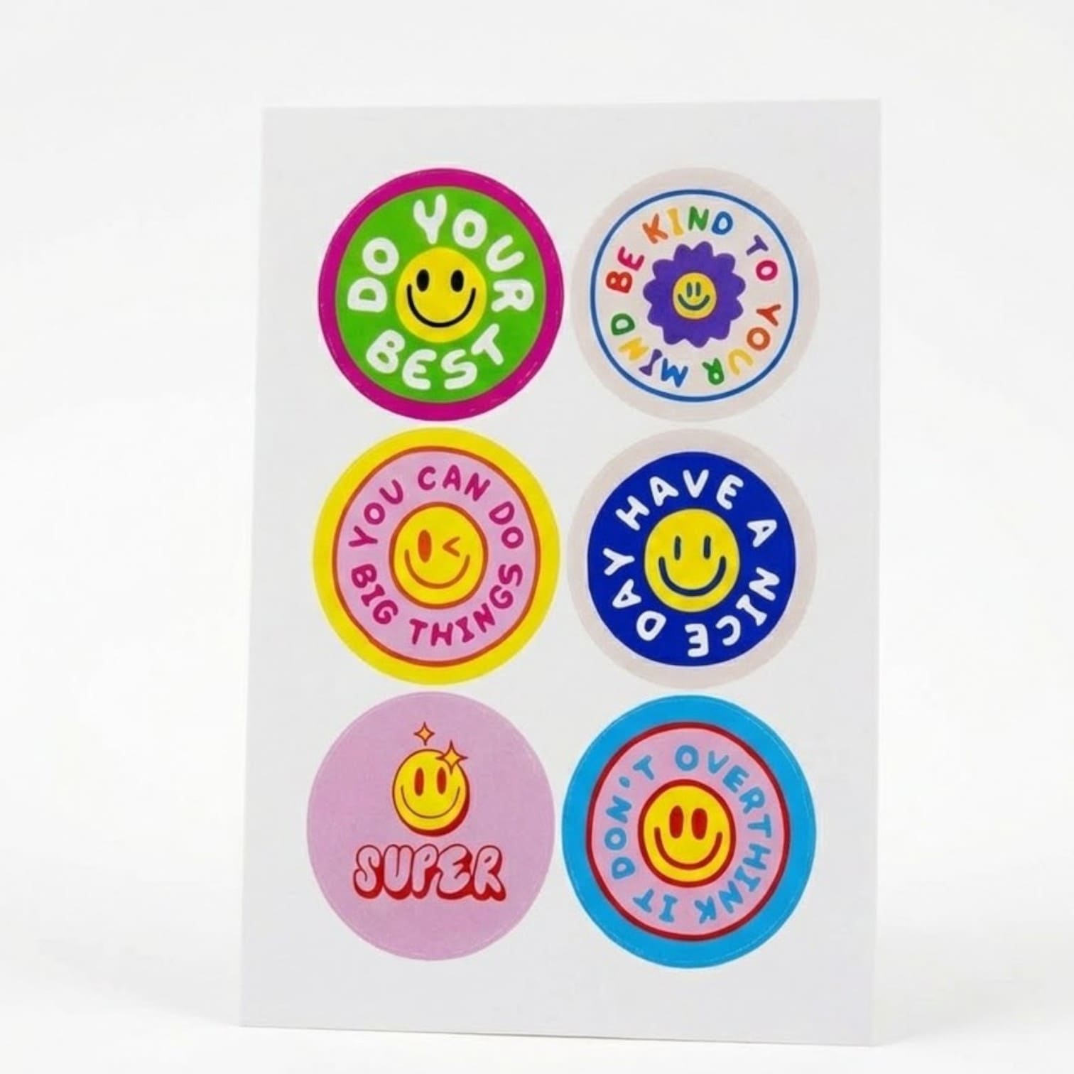 Sheet of colorful smiley face stickers with positive phrases, inspired by fun product trends.