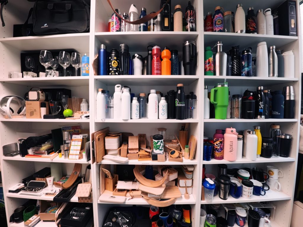 A closet shelf in the Sydney showroom filled with water bottles, mugs, and kitchen items.