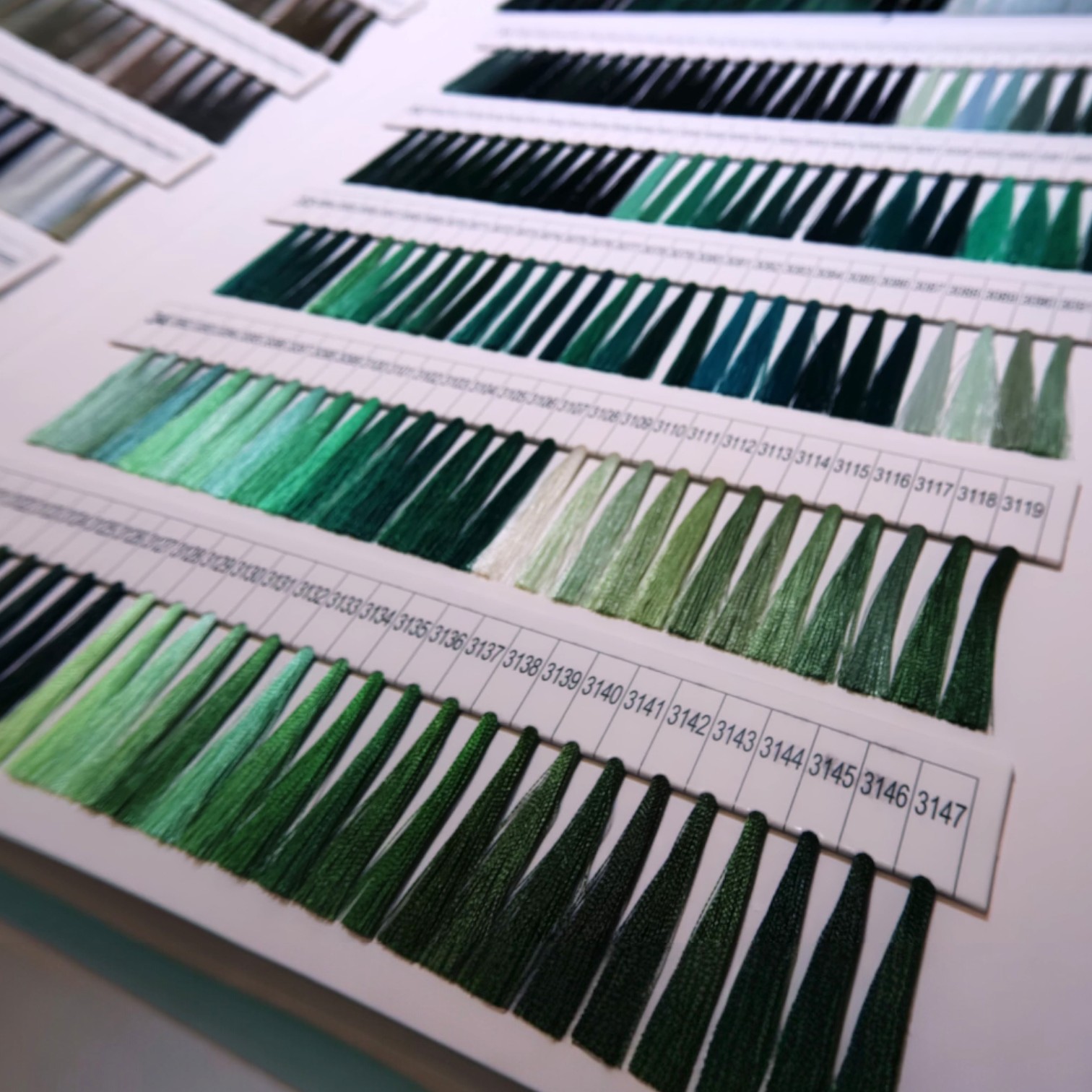 Rows of green thread samples labeled with numbers show print colour accuracy on a white background.