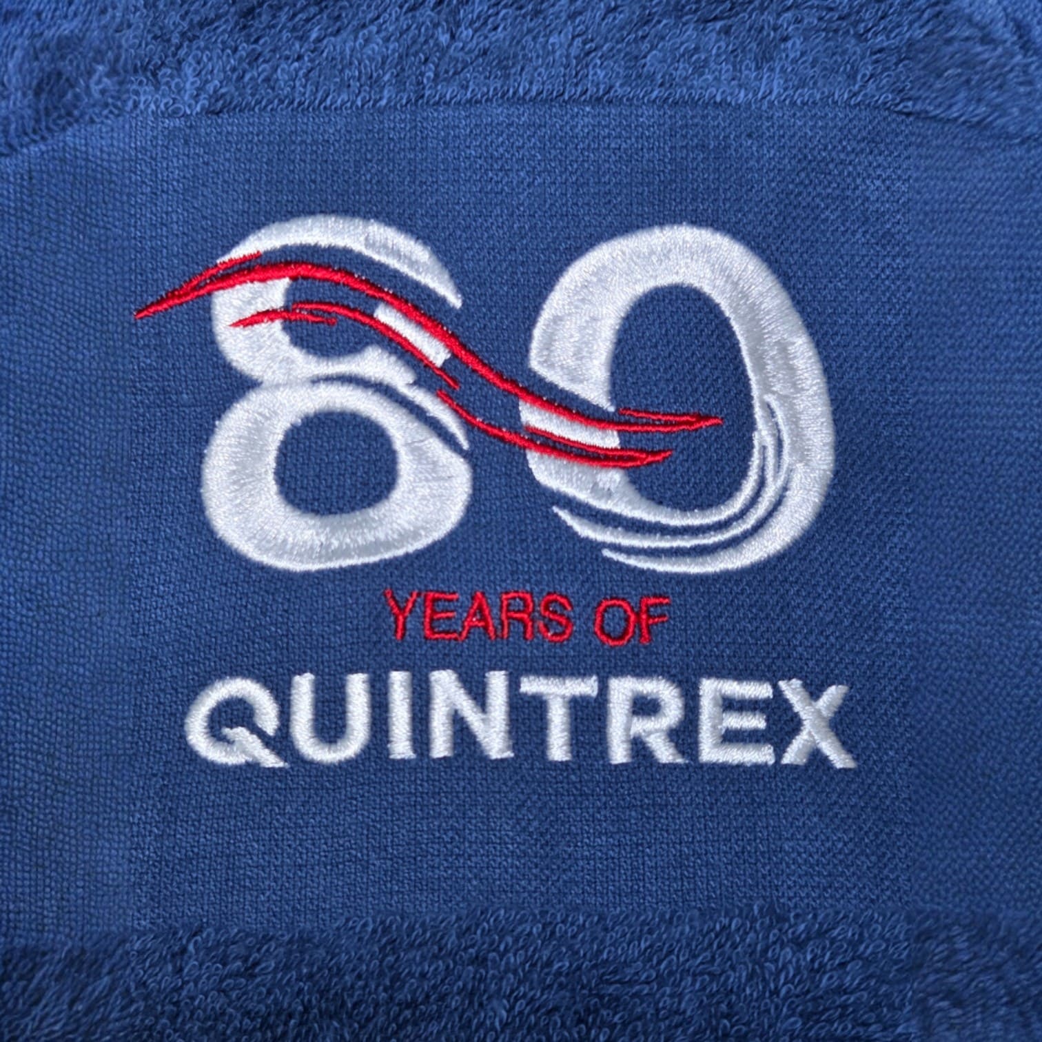 Blue fabric with 80 Years of Quintrex embroidered for sharp print colour accuracy.