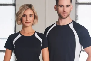 Two people wearing matching cool dry shirts in black and white standing indoors.