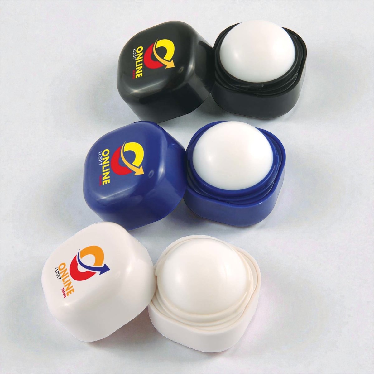 Three square lip balm containers—an unusual promo product—in black, blue, and white.