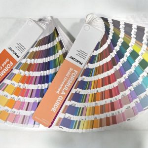 Pantone color swatches fanned out to check print colour accuracy on a white surface.