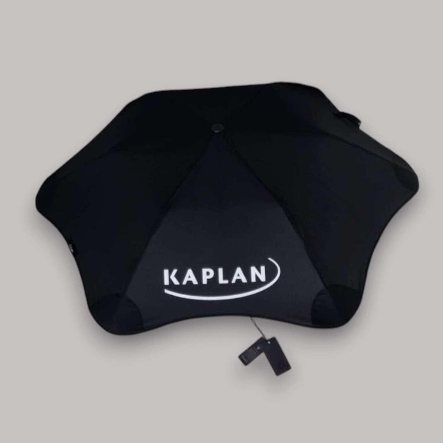 Black umbrella with KAPLAN logo in white, ideal for Australian B2B Promo Packs, on gray background.
