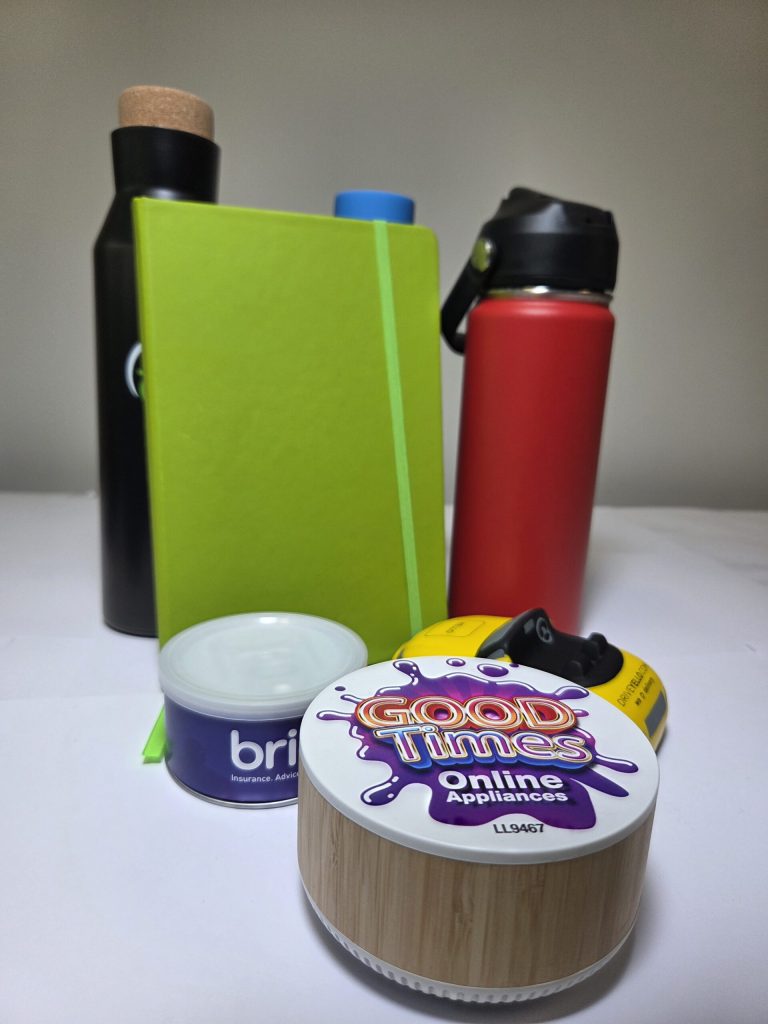 A green notebook, bottles, and containers showcase subtle branding colours on a white surface.
