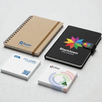 Two branded notebooks and sticky notes make a perfect promotional item on a light surface.