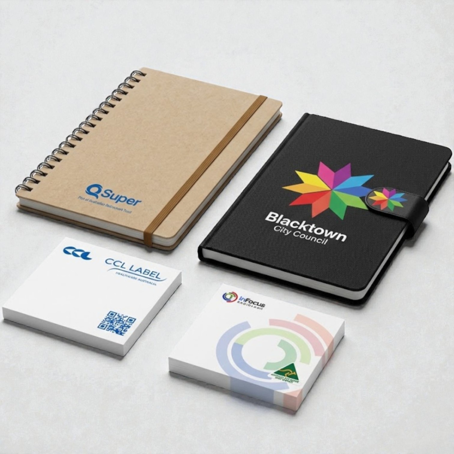 Two branded notebooks and sticky notes make a perfect promotional item on a light surface.