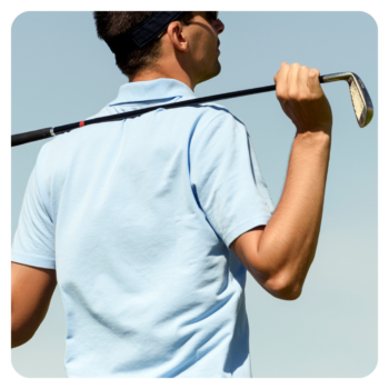 Man in a light blue corporate golf shirt holds a club over his shoulder in timeless style.