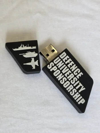 A Cap USB Drive labeled Defence University Sponsorship with military vehicle icons.